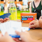 Friends playing You-phemism with the game box on the table
